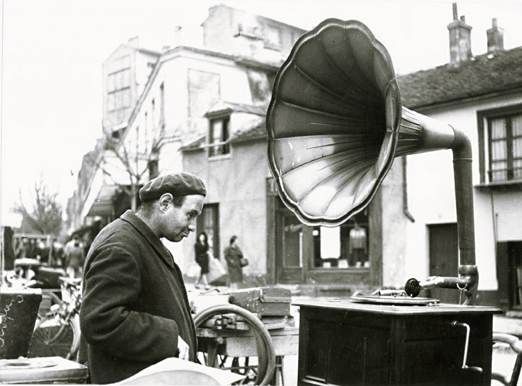 Robert Doisneau - Man and Phonograph at the Flea Market (Marché aux puces du Kremlin Bicêtre) Robert Doisneau - Man and Phonograph at the Flea Market (Marché aux puces du Kremlin Bicêtre)