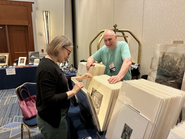 Diane Waggoner, Curator of Photographs at the National Gallery of Art, peruses the offerings at Alex Novak's table at last year's show in Hartford. (Photo by Dave Fondiller)